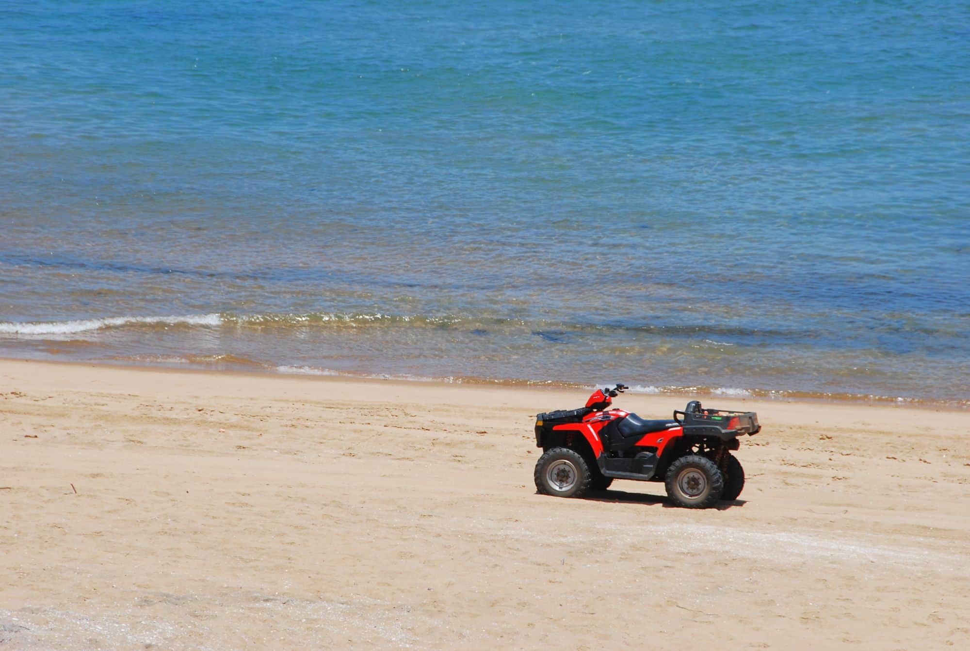 Quad rouge roulant au bord de l'océan